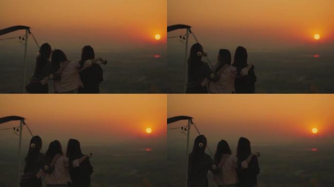 团体亚洲女青年欣赏山上日落美景
