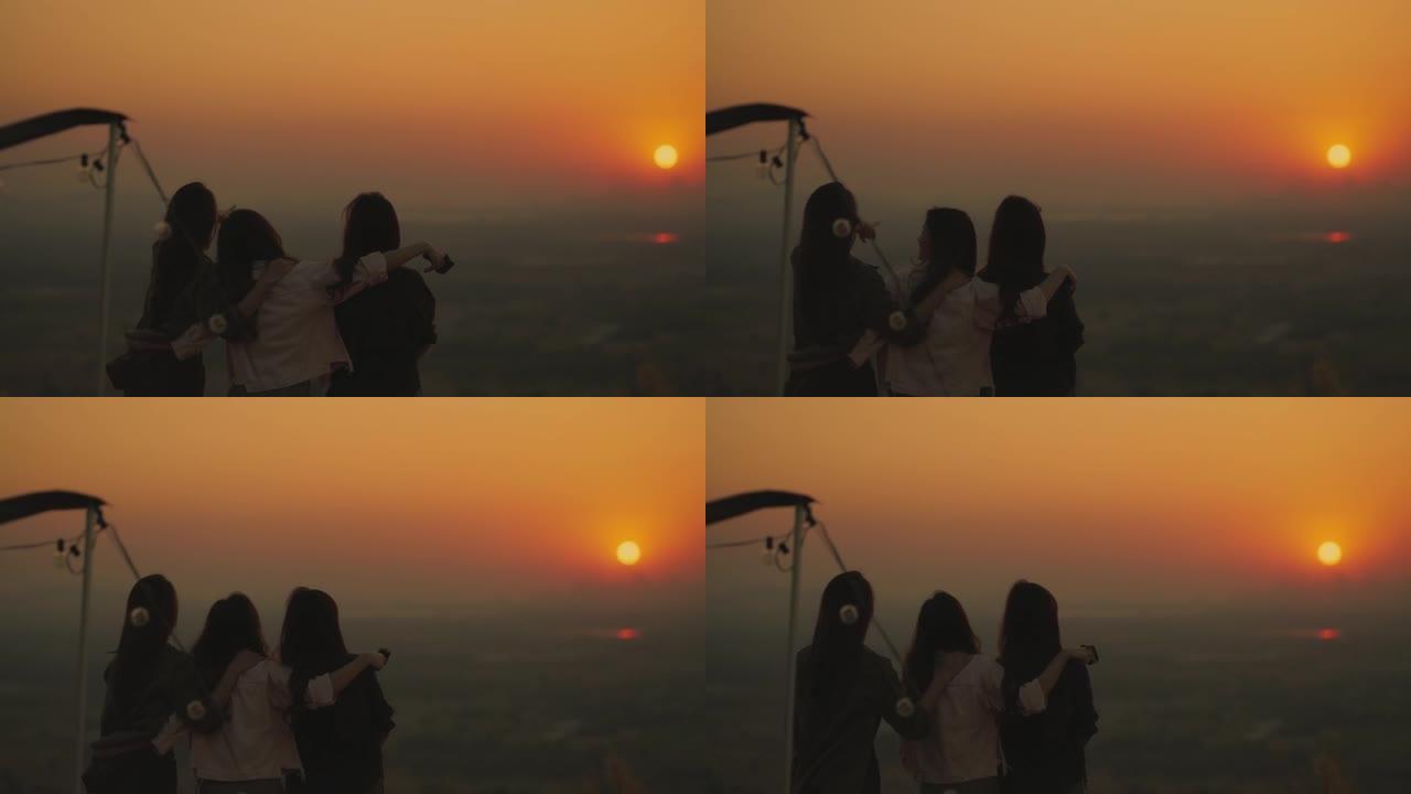 团体亚洲女青年欣赏山上日落美景