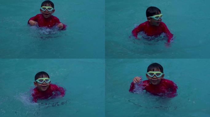 4k慢动作，一个穿着红色泳衣和护目镜的亚洲男孩正试图在游泳池里游泳，摆动双腿以获得快乐。在家庭度假时