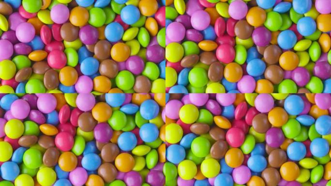 慢动作特写圆形彩色巧克力糖果，糖衣糖衣。旋转和秋季五彩巧克力糖果