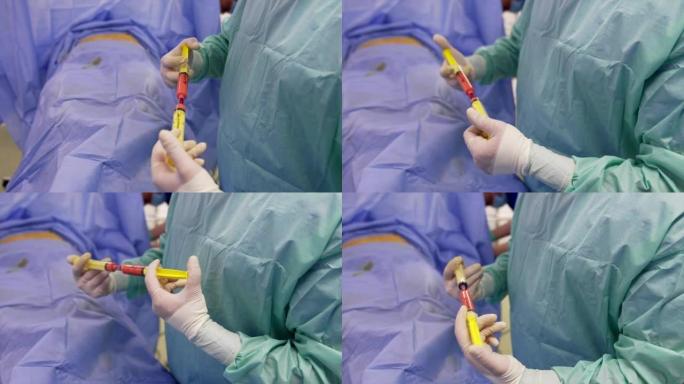 军医手中的两个注射器。医生在术前准备干细胞的乳胶手套。特写。