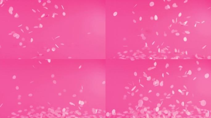 粉色背景上的五彩纸屑。慢动作。