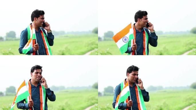 农民在绿色的田野上用手机通话，手里拿着国旗