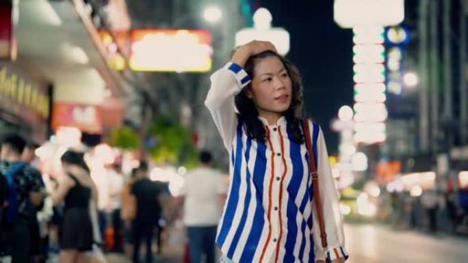 4K，一位长发的亚洲妇女在唐人街著名的购物区，夜市，旅游景点和购物场所的街道上散步，适合散步和寻找食