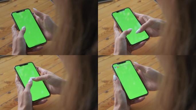 Womans hands hold smartphone which green screen