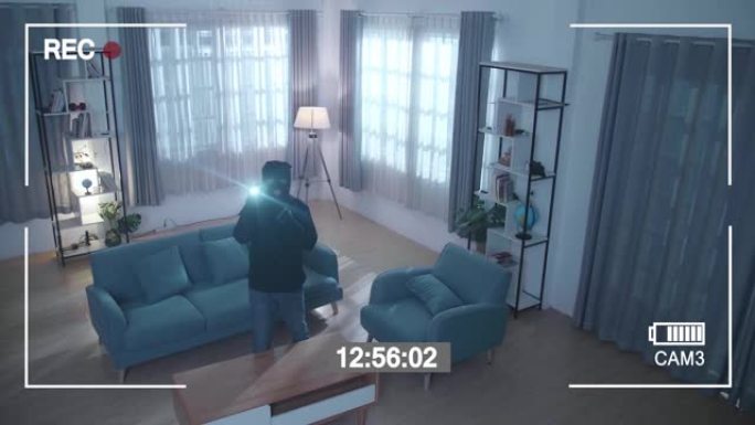 监视器的屏幕记录了一个用手电筒在屋子里行走的小偷