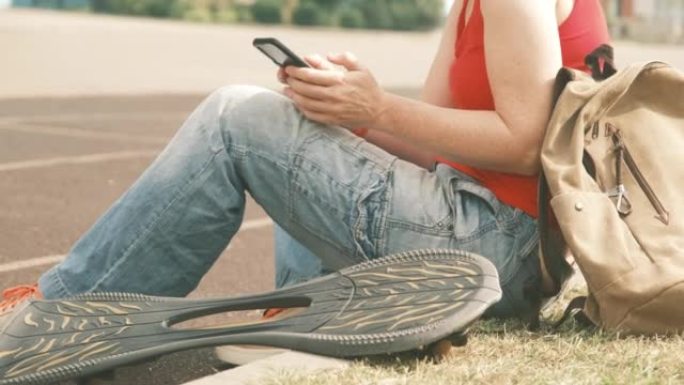 活跃的成熟女人坐在人行道上，而滑板则躺在附近