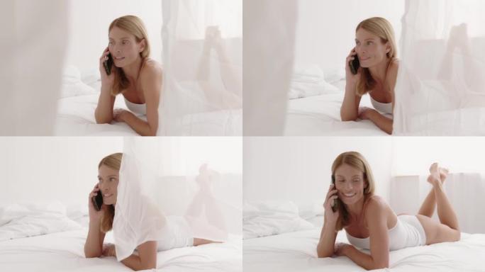 中年金发女子用智能手机打电话躺在家里的床上