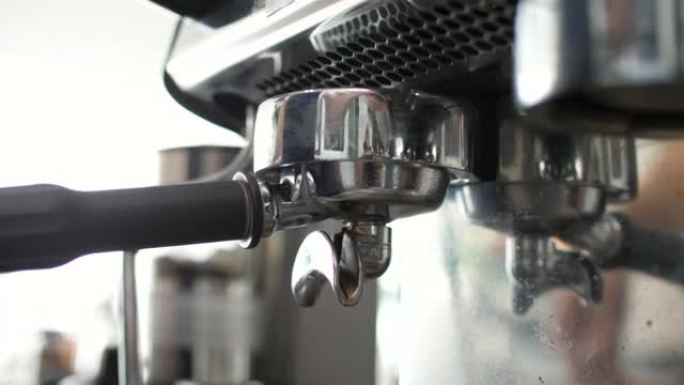 浓缩咖啡机喷口和小咖啡杯的特写镜头