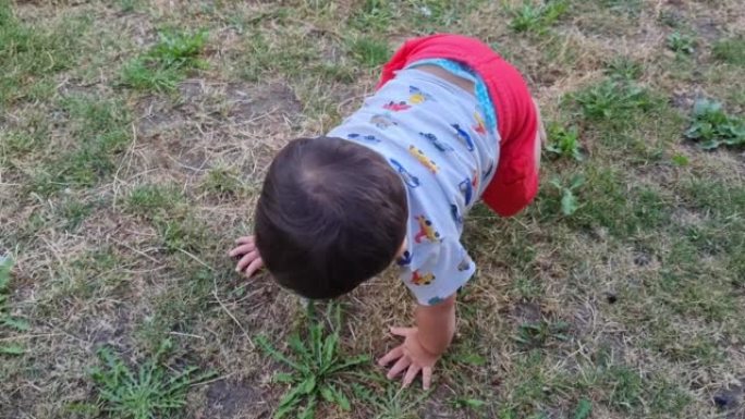 婴儿穿着夏天的休闲装在家庭花园玩耍