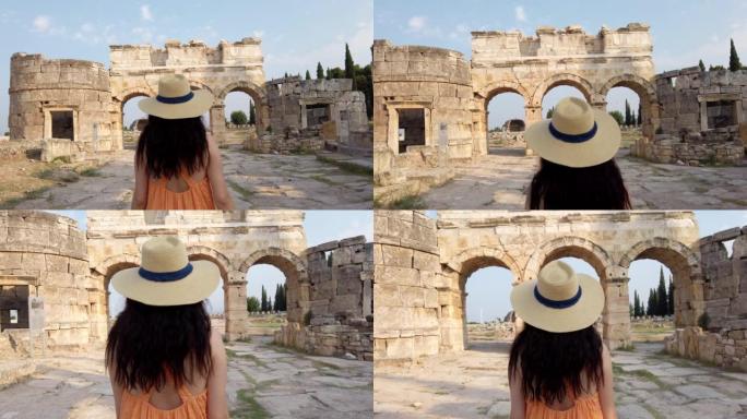 在德尼兹利的Pamukkale，游客女孩正走向希拉波利斯古城遗址的Frontinus Gate