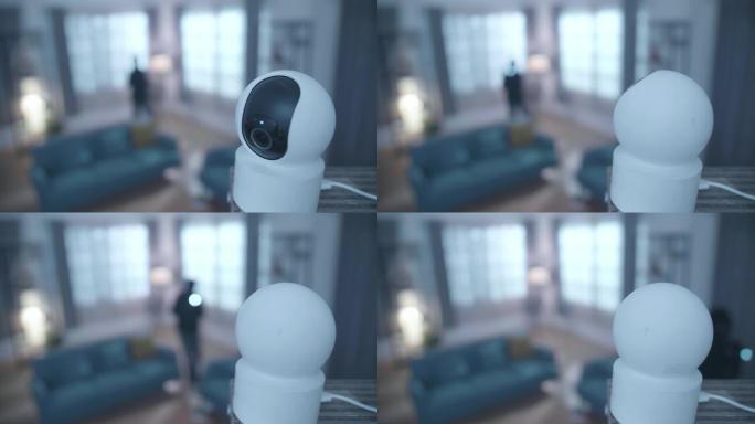 闭路电视摄像机正在工作，而一个带手电筒的小偷在某人的房子里行走