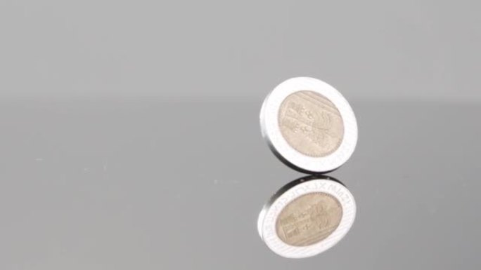 新的以色列谢克尔硬币在反光表面上慢动作落下