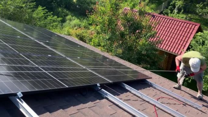 Man在屋顶上工作，准备安装新一代有效的太阳能电池板。DIY光伏面板组件