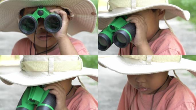 观察的小男孩学习用双筒望远镜进行户外探索。