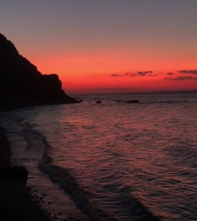 海浪和美妙的红色空气的日落垂直拍摄视频