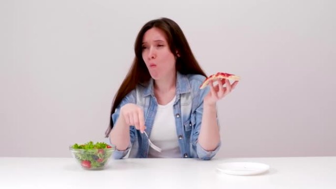 节食的年轻女子想吃披萨，但选择了沙拉