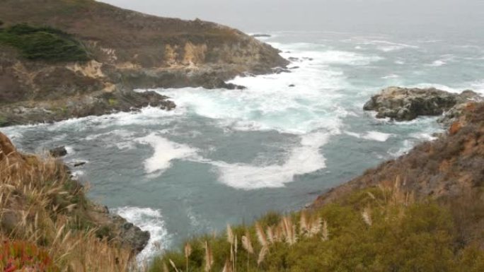 岩石崎岖的海洋，有雾的天气。海浪冲击海滩。加利福尼亚，大苏尔。