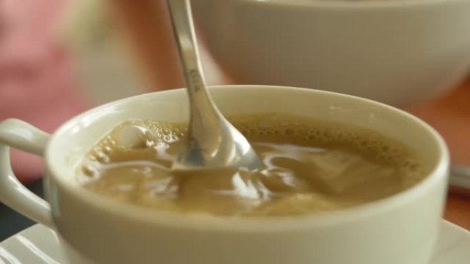 在咖啡杯中搅拌糖。