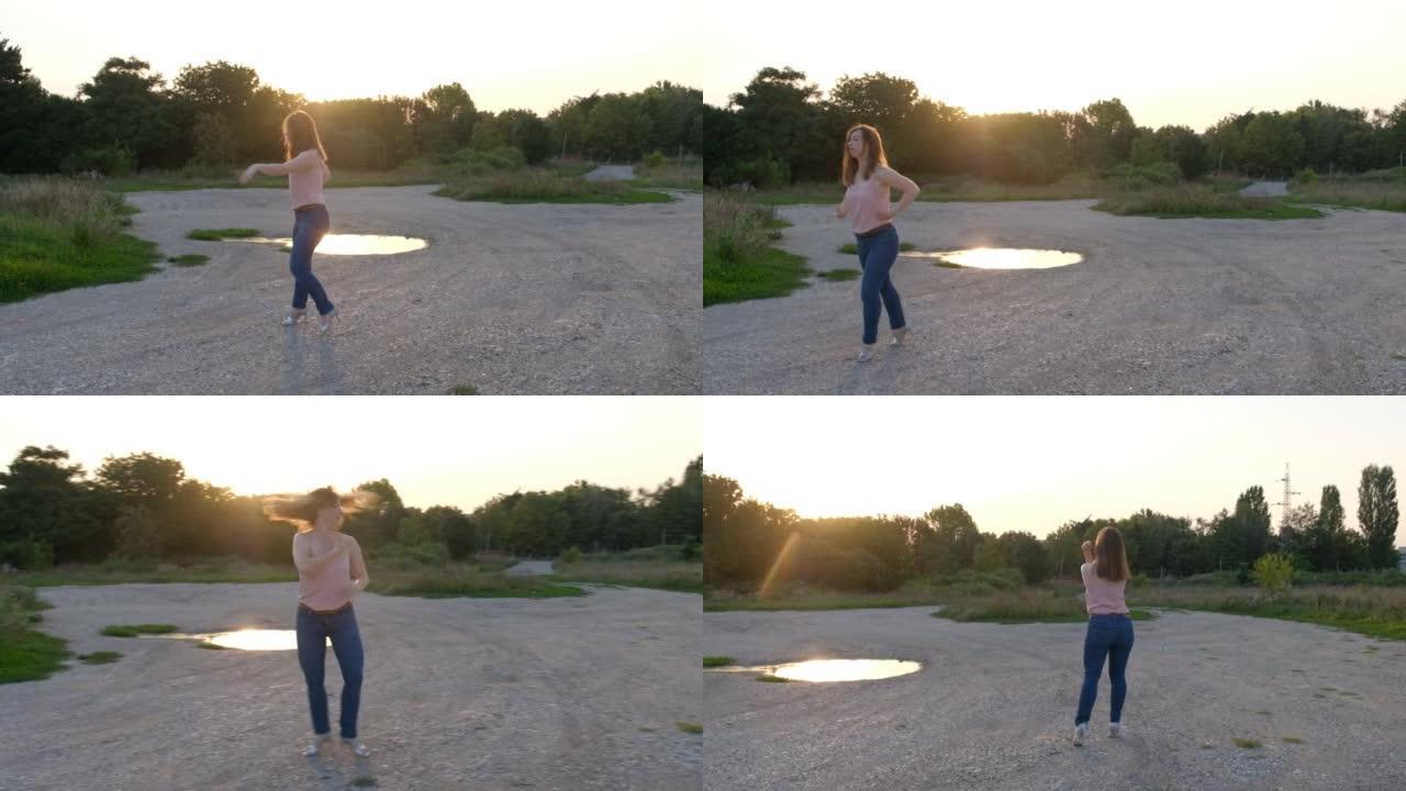 穿着牛仔裤和鞋子的年轻女子在户外日落时跳舞