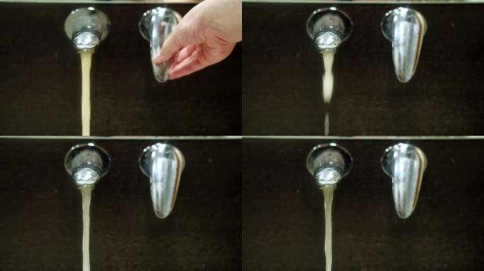 生锈的脏水从水龙头流入家用水槽