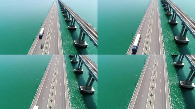用移动的车辆在新的白色桥上方飞行。行动。令人叹为观止的海洋景观，在蓝色平静的水面上有一座长桥。