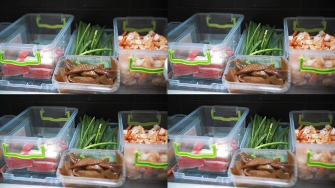 食品。俯视图。特写。塑料容器中的海鲜。蟹棒、黄瓜切片、鱼、鳗鱼、煮虾。制作寿司的半成品。烹饪。