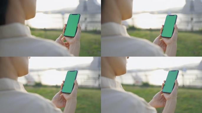 绿屏手持智能手机上的女人