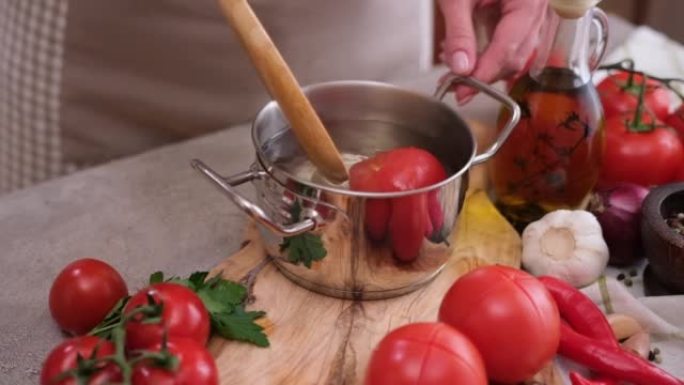 女人用热开水在锅里烫番茄
