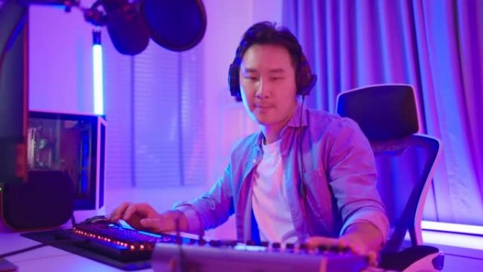 亚洲青年音频DJ男在麦克风上唱歌广播。迷人的美丽男人博客影响者戴着耳机，为家庭广播电台录制早间新闻播