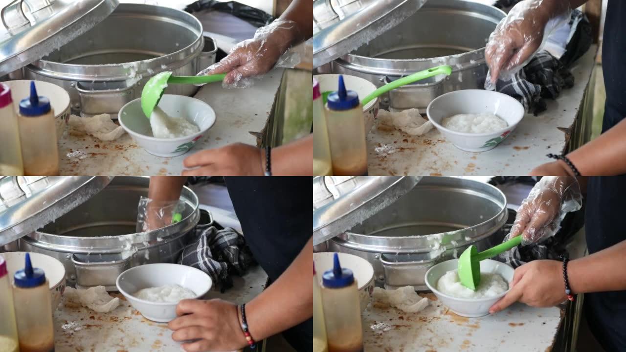 鸡肉粥销售商或tukang bubur ayam正在为顾客或pelanggan准备饭菜。Bubur 