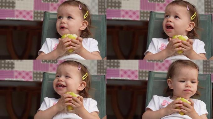 一个女孩小高加索蹒跚学步的孩子在户外复制空间吃梨