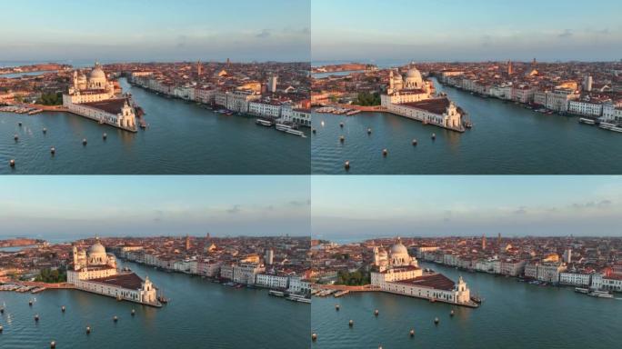 无人机日落场景的圣玛丽亚德拉致敬罗马天主教教堂和小大教堂与交通船之间的大运河和朱代卡运河