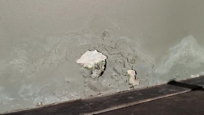 旧建筑的墙壁开裂，修复不良，油漆剥落。