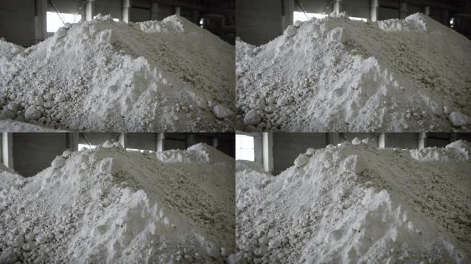 仓库储存生产用原材料。一堆准备好的白色粘土。
