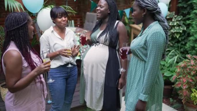 微笑的年轻孕妇与最好的朋友一起庆祝婴儿送礼会。