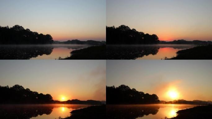 夏天的早晨，日出在河上的时光倒流。太阳从岸上的地平线后面升起，逐渐变成橙色变成日光，并在水面上反射。