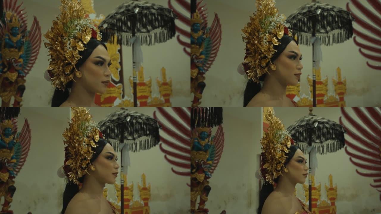 一位穿着金色服装的迷人巴厘岛妇女站在巴厘岛大门之间
