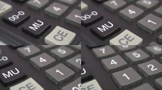 计算器键盘特写视图。黑色计算器按钮，选择性对焦。一种大量使用的旧会计工程计算器，按钮之间有污垢。多莉