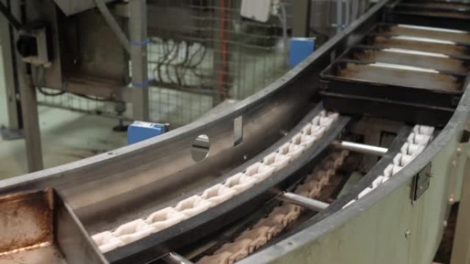 面包店工厂的传送带上的空烤盘