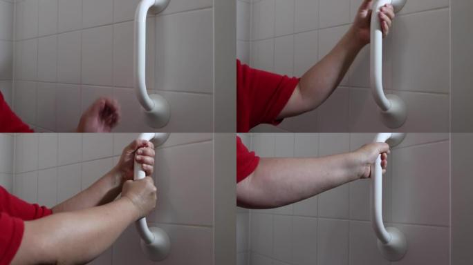 成年女性手握在浴室厕所旁边的安全杆上