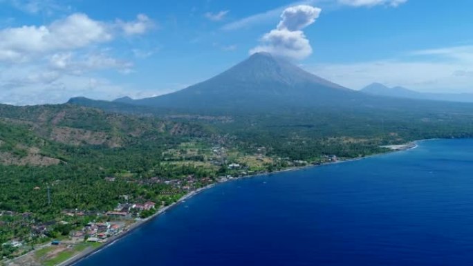 岛屿海岸，背景为黑沙滩和火山爆发