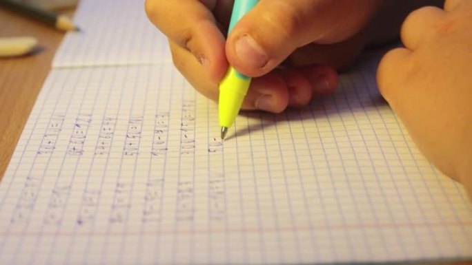 学生的双手特写在笔记本上写数学示例。