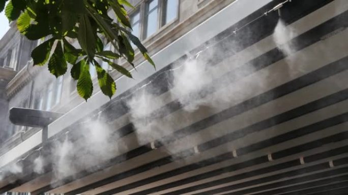 炎热天气下夏季餐厅和咖啡馆的喷水系统。在炎热的天气里，喷气机将水喷入喷雾中，以使餐厅顾客精神焕发。