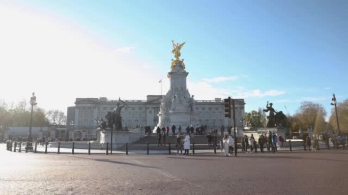在英国伦敦一个阳光明媚的冬日里，白金汉宫与维多利亚雕像的时间流逝