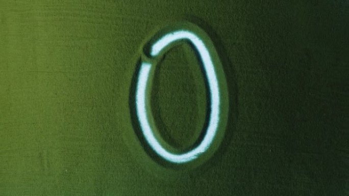 绿色沙子中的手工绘制数字零0符号。