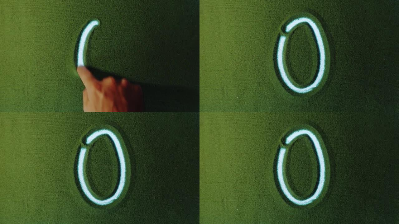 绿色沙子中的手工绘制数字零0符号。