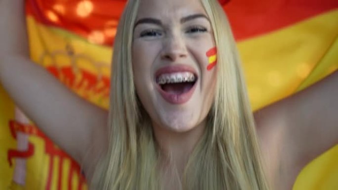 庆祝挥舞西班牙国旗的年轻女子