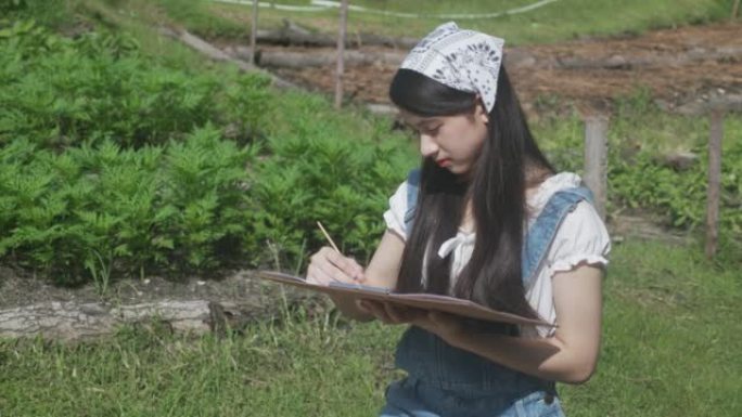 年轻的亚洲妇女坐在夏天公园里休闲时用五颜六色的画笔画画，艺术家和技术有专长，女孩画画有才华是爱好，生