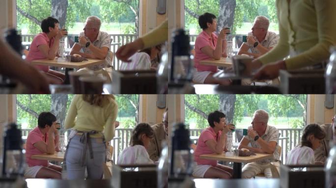 老年夫妇一边喝咖啡一边聊天，在餐厅放松
